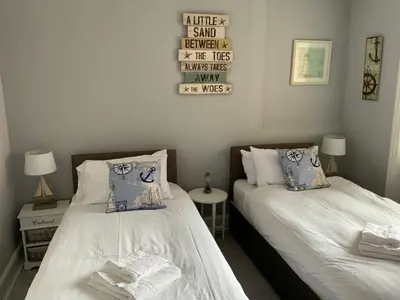 a bedroom with two beds and a sign on the wall at The Glenroy Guest House in Blackpool