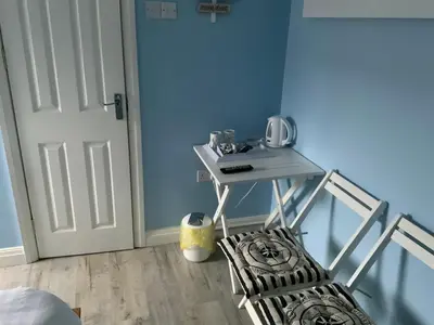 a room with a table and a chair next to a door at The Glenroy Guest House in Blackpool