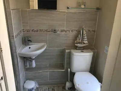 a bathroom with a toilet and a sink with a boat on it at The Glenroy Guest House in Blackpool