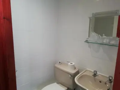 a bathroom with a toilet and a sink and a mirror at The Penrhyn in Blackpool