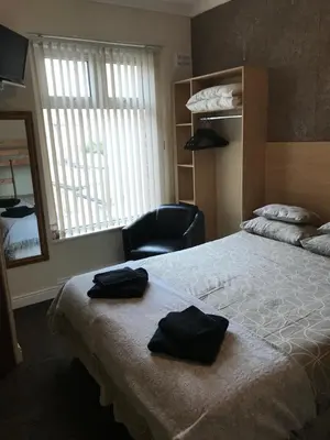 a bedroom with a bed with two black towels on it at The Penrhyn in Blackpool