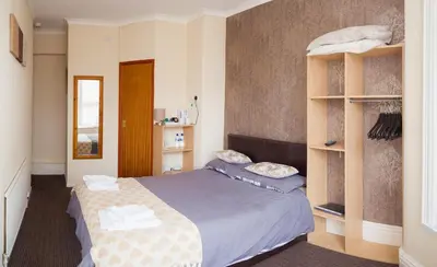 a bedroom with a bed and a book shelf at The Penrhyn in Blackpool