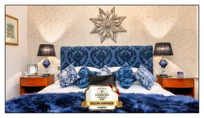 a bed with blue pillows and a star on the wall at Pembroke Hotel in Blackpool
