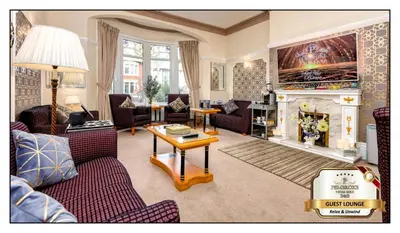a living room with a couch and a fireplace at Pembroke Hotel in Blackpool
