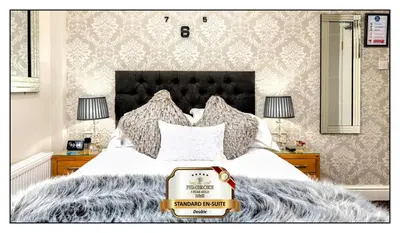 a bedroom with a bed with a suitcase on it at Pembroke Hotel in Blackpool