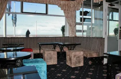 a restaurant with tables and chairs and a large window at The Blenheim Mount Hotel in Blackpool