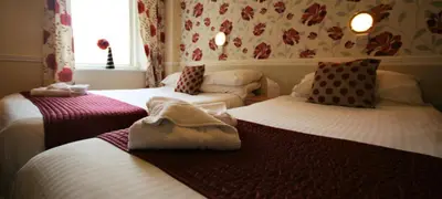 a room with two beds with towels on them at The Blenheim Mount Hotel in Blackpool