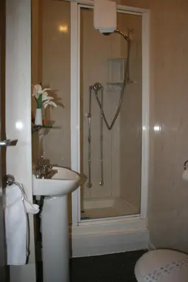 a bathroom with a shower and a sink and a toilet at The Blenheim Mount Hotel in Blackpool