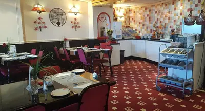 a dining room with tables and chairs in a restaurant at The Blenheim Mount Hotel in Blackpool