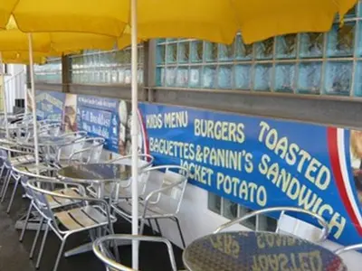 a row of tables and chairs under an umbrella at Dutchman Hotel in Blackpool