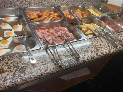 a buffet of food with eggs and meats and french fries at Dutchman Hotel in Blackpool