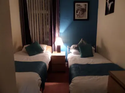 a room with two beds and a lamp in it at The Grays in Blackpool