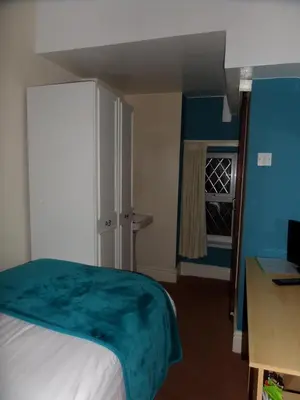 a bedroom with a bed and a desk and a window at The Grays in Blackpool