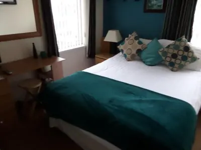 a bedroom with a bed with a green and white blanket at The Grays in Blackpool