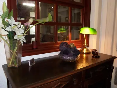 a table with a vase of flowers and a lamp at The Grays in Blackpool