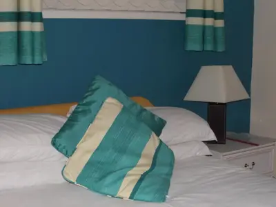 a green and white pillow sitting on top of a bed at The Grays in Blackpool