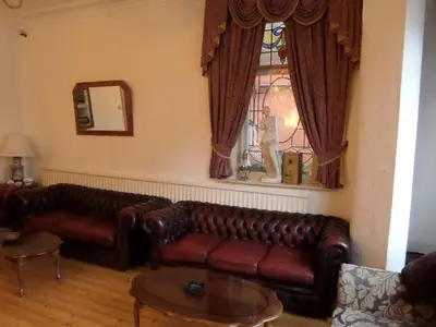 a living room with two leather couches and a window at The Grays in Blackpool