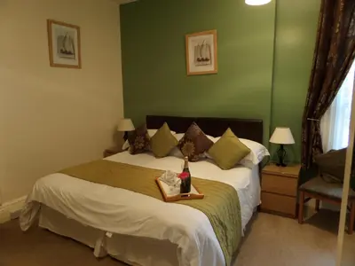a bedroom with a bed with a bottle of wine on it at The Grays in Blackpool