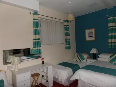 a room with two beds and a desk in it at The Grays in Blackpool