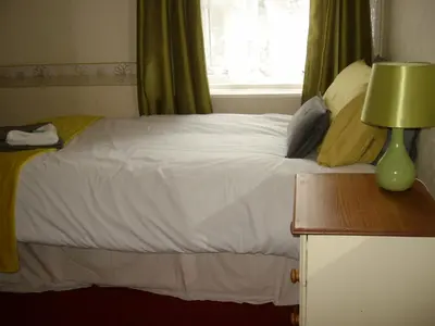 a bedroom with a bed with white sheets and a window at Vista Sol in Blackpool