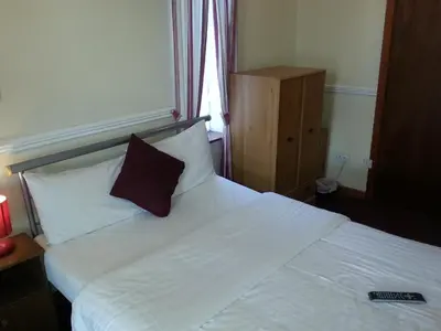 a bedroom with a white bed with a pillow on it at Lynwood Hotel in Blackpool