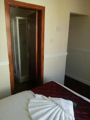 a room with a bed with a mirror and a door at Lynwood Hotel in Blackpool