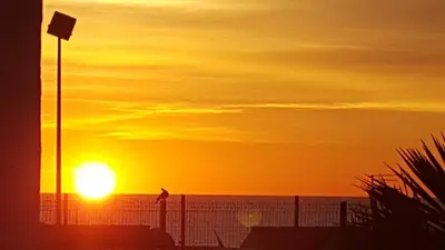 a sunset on the beach with the sun in the sky at Lynwood Hotel in Blackpool