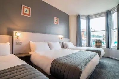 a hotel room with two beds and a window at Comfort Inn Blackpool Gresham in Blackpool