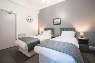 two beds in a small room with two lamps at Comfort Inn Blackpool Gresham in Blackpool
