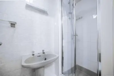 a white bathroom with a sink and a shower at Comfort Inn Blackpool Gresham in Blackpool