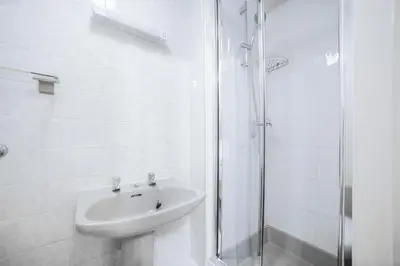 a white bathroom with a sink and a shower at Comfort Inn Blackpool Gresham in Blackpool