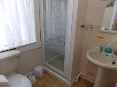 a bathroom with a shower and a toilet and a sink at Topaz Blackpool in Blackpool