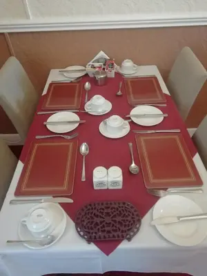 a table with red and white plates and utensils at Shirley Heights Hotel in Blackpool