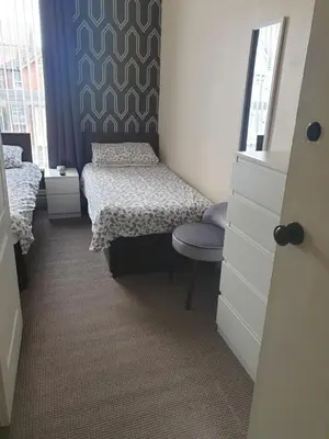 a small bedroom with a bed and a chair at Langroyd Hotel in Blackpool