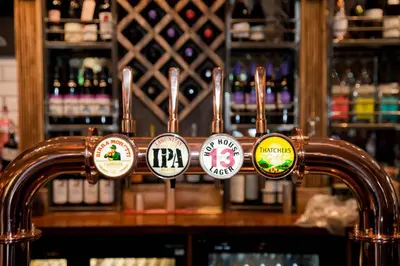 a bar with a bunch of stickers on the counter at The Royal Hotel in Bolton le Sands