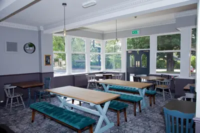 a dining room with tables and chairs and windows at The Royal Hotel in Bolton le Sands