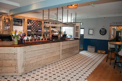 a bar in a restaurant with a counter at The Royal Hotel in Bolton le Sands