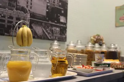 a table with glasses of orange juice and a plate of fruit at The Hollingworth in Lytham St Annes