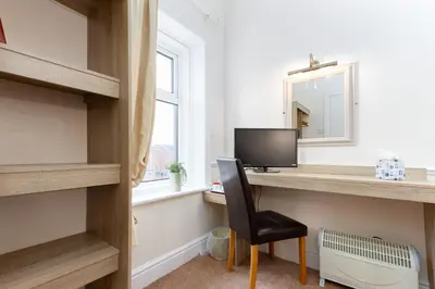 a room with a desk with a computer and a chair at The Hollingworth in Lytham St Annes