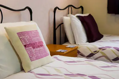 a hotel room with two beds with a pillow on it at The Claremont in Lytham St Annes