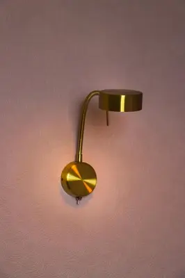 a gold lamp hanging on a pink wall at The Claremont in Lytham St Annes