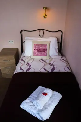 a bed with two towels sitting on top of it at The Claremont in Lytham St Annes