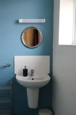 a bathroom with a white sink and a mirror at The Claremont in Lytham St Annes