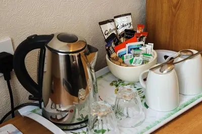 a tea kettle on a table with a basket of food at The Claremont in Lytham St Annes