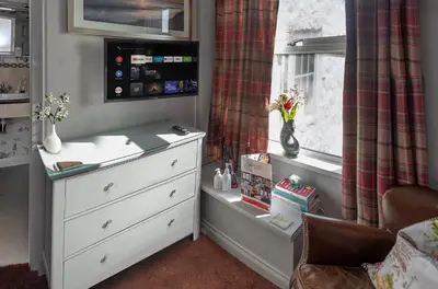 a childs bedroom with a dresser and a window at The Broadwater Guest House in Morecambe