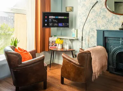 a living room with two chairs and a fireplace at The Broadwater Guest House in Morecambe
