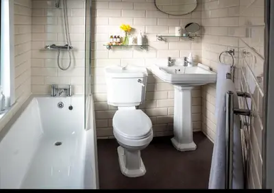 a white bathroom with a toilet and a sink at The Broadwater Guest House in Morecambe