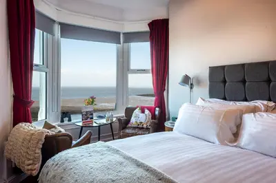 a bedroom with a bed and a view of the ocean at The Broadwater Guest House in Morecambe