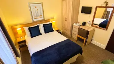 a hotel room with a bed and a mirror at Sutcliffe Hotel in Blackpool