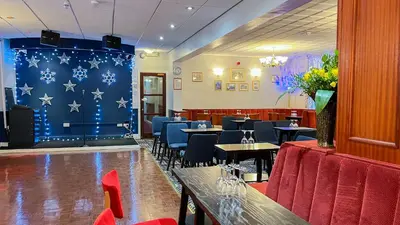 a restaurant with tables and chairs and a blue wall with stars at Sutcliffe Hotel in Blackpool